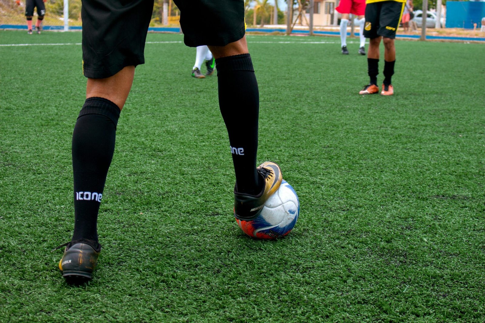 Close-up of a soccer player controlling the ball during a match on a green field.