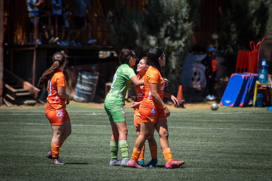 Female soccer players in action during an outdoor match, showcasing teamwork and sportsmanship.
